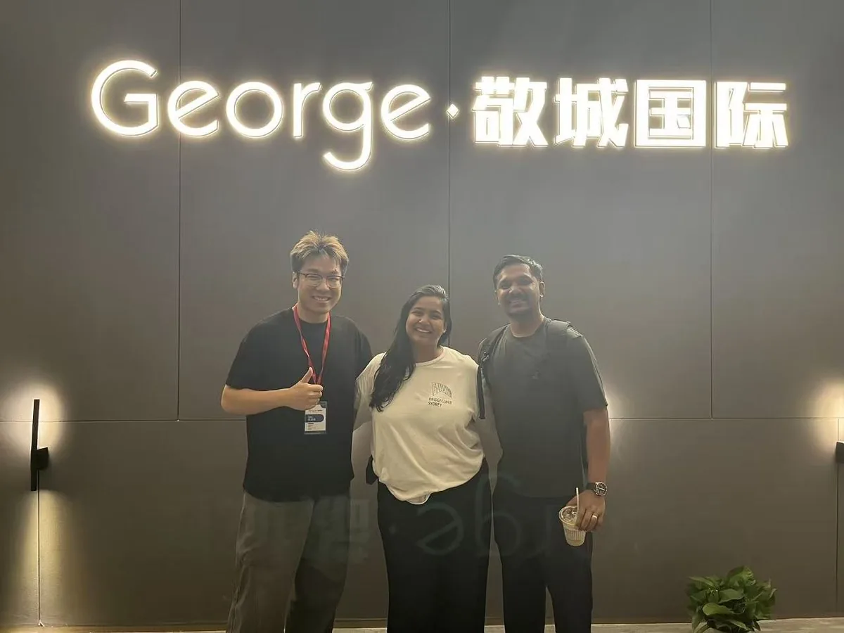 Partners in front of the George headquarters sign