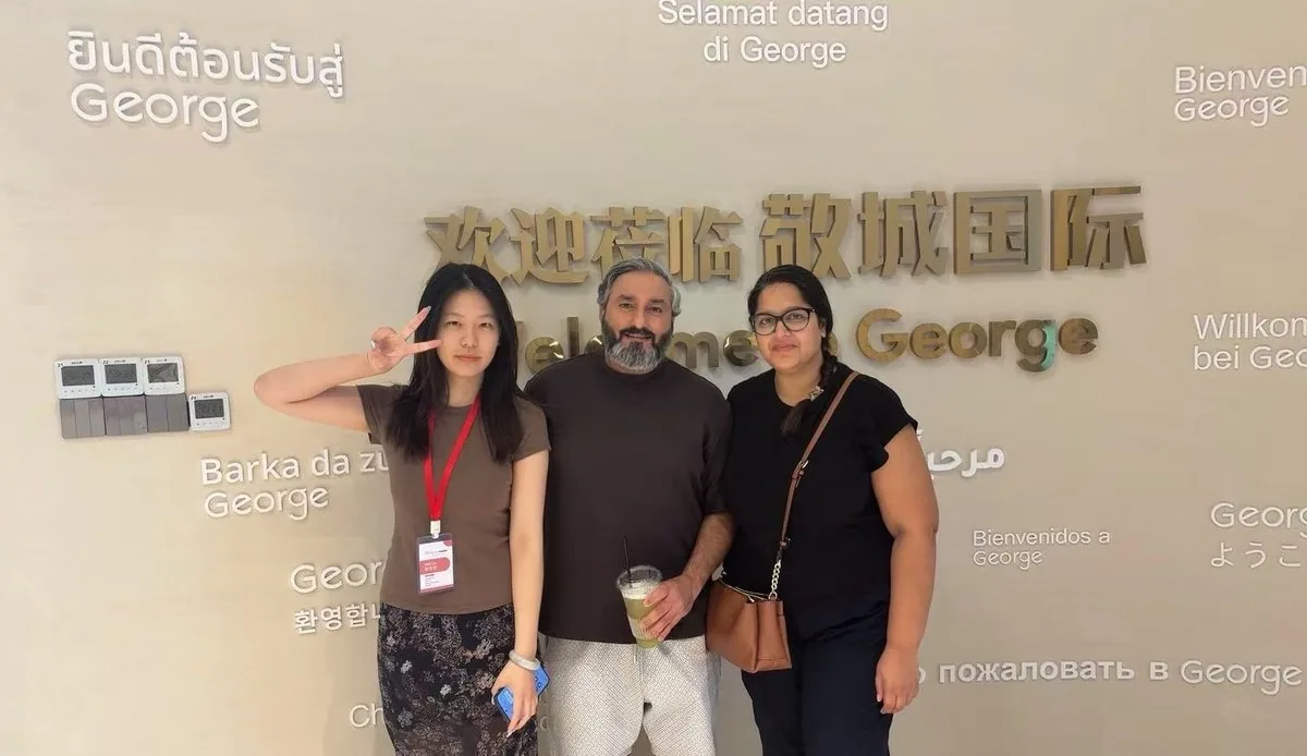 Partners taking a photo at the welcome wall